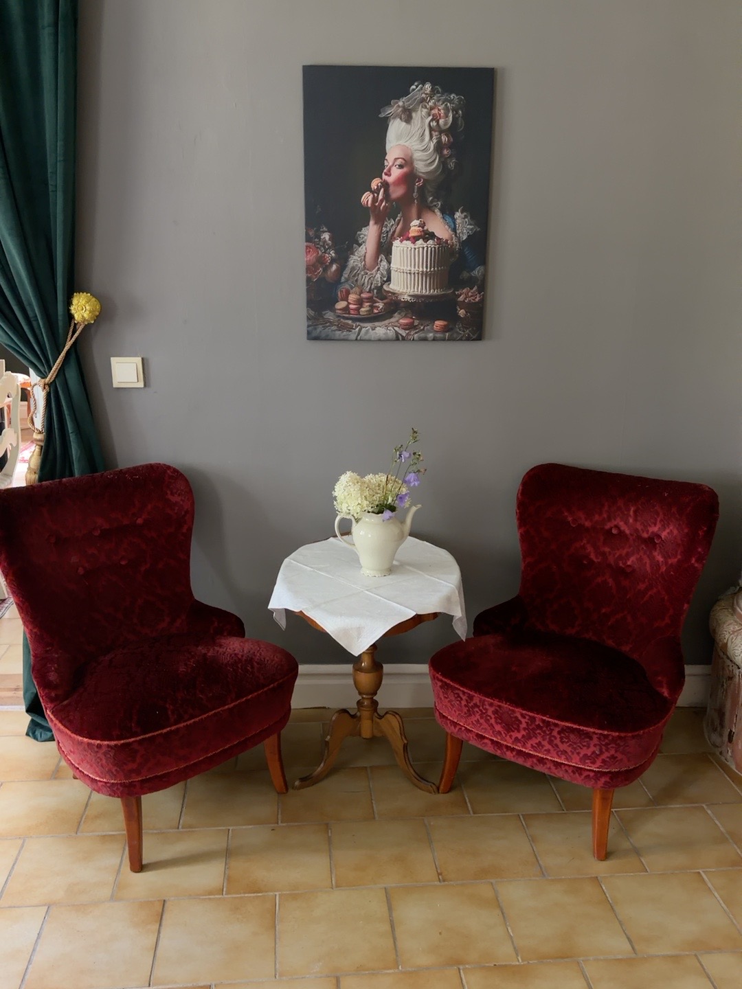 Två röda sammetsfåtöljer och ett litet bord i caféet